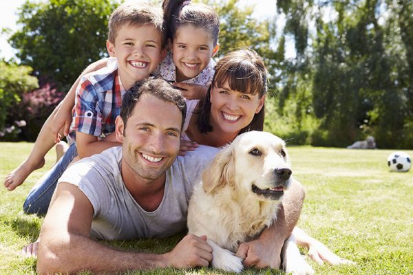 Happy family of four and their dog outdoors