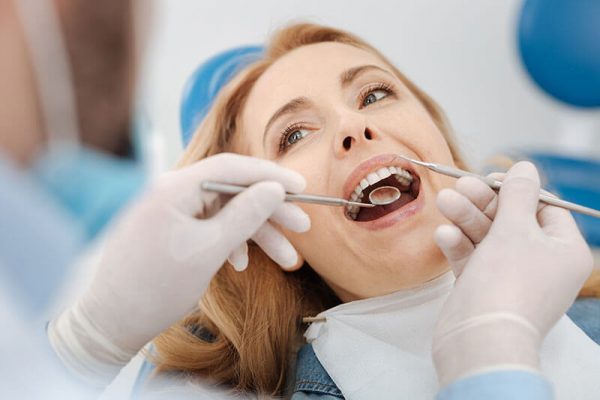 Middle-aged female patient getting her teeth examined