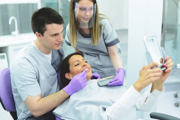 Female patient looking at veneers with the dentist