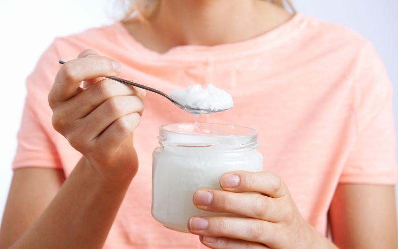 woman holding a jar of coconut oil